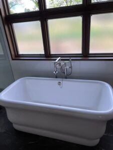 a white bathtub sitting in front of a window