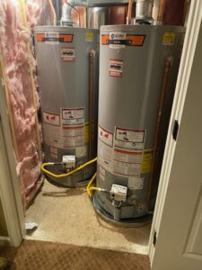 two water heaters in a room with insulation