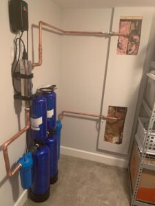 a water softener system in a room with pipes