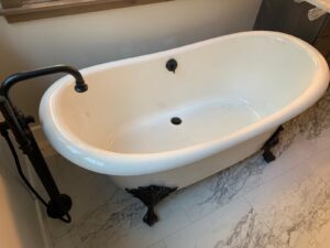 a white bathtub with a black faucet and sink