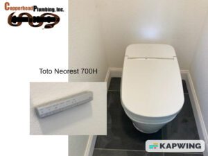 a toilet with a white seat and a white wall